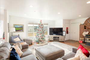 Living area with light wood-type flooring and recessed lighting