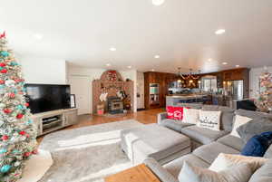 Living room featuring light wood-type flooring, a wood stove, and recessed lighting