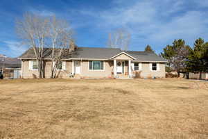 Single story home with entry steps, a chimney, and a front yard