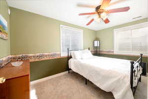 Bedroom featuring ceiling fan, baseboards, visible vents, and light colored carpet