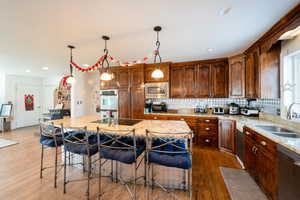 Kitchen with decorative light fixtures, stainless steel appliances, a sink, and a center island