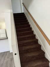 Stairs featuring hardwood / wood-style floors