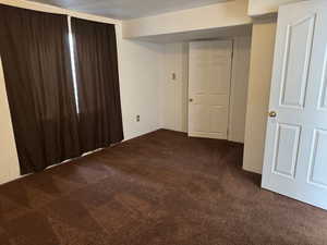 Empty room featuring dark colored carpet