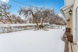 Yard covered in snow with fence