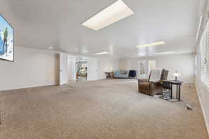 Sitting room with a textured ceiling, carpet floors, and visible vents