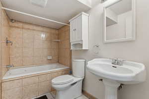 Bathroom featuring visible vents, tiled shower / bath combo, tile patterned flooring, and toilet