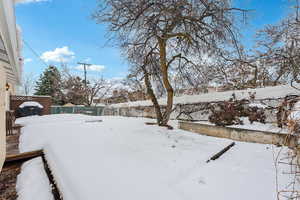 Yard covered in snow featuring a fenced backyard