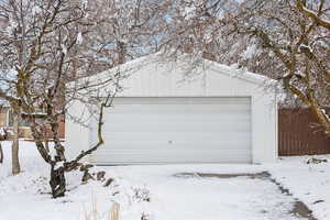 Snow covered garage featuring a garage