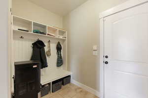 Mudroom with baseboards, a textured ceiling, and light tile patterned flooring