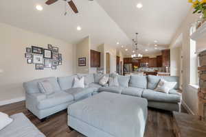 Living area featuring recessed lighting, dark wood-style flooring, vaulted ceiling, and baseboards