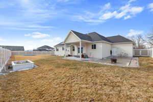 Rear view of house with a yard, a patio area, a fenced backyard, and stucco siding