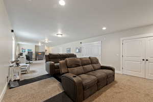 Living room with recessed lighting, light colored carpet, and baseboards