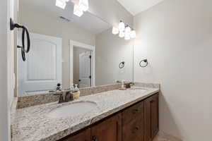 Bathroom featuring double vanity, a sink, and visible vents