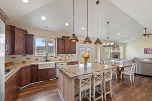 Kitchen featuring open floor plan, a breakfast bar, a center island, a sink, and stainless steel dishwasher