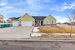 Craftsman house with concrete driveway, board and batten siding, an attached garage, and fence