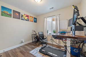 Interior space featuring baseboards, visible vents, and wood finished floors