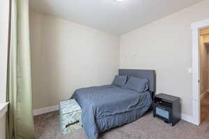 Bedroom with baseboards and light colored carpet