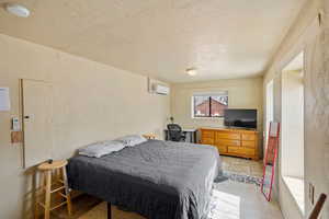 Bedroom featuring a wall mounted air conditioner and stone tile floors