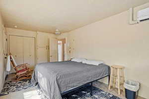 Bedroom with light tile patterned floors, a closet, and a wall mounted AC