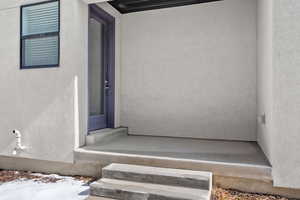 Doorway to property with stucco siding