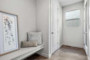 Mudroom with light wood-style flooring and baseboards