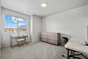 Home office featuring visible vents, light colored carpet, a textured ceiling, and baseboards