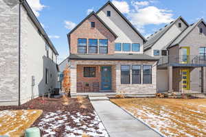 View of front of home with stone siding and central air condition unit