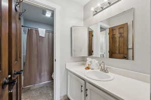 Bathroom with toilet, a shower with curtain, and vanity