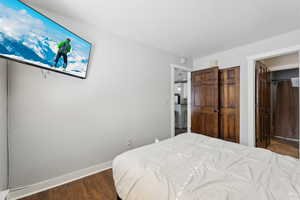 Bedroom featuring dark wood finished floors and baseboards