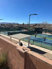 View of tennis court featuring fence and a mountain view