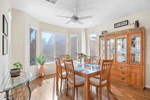 Dining space featuring light wood-style floors, plenty of natural light, baseboards, and a ceiling fan