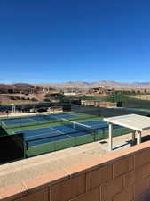 View of tennis court featuring a mountain view and fence