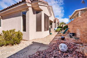 View of property exterior with a tiled roof, fence, a patio, and stucco siding