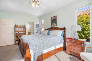 Bedroom featuring a ceiling fan, light colored carpet, and connected bathroom