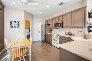 Kitchen featuring visible vents, appliances with stainless steel finishes, light countertops, a sink, and recessed lighting