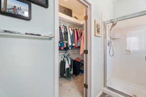 Bathroom with a stall shower and a walk in closet