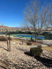 View of pool featuring a tennis court, fence, and a mountain view