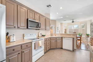 Kitchen featuring appliances with stainless steel finishes, light countertops, visible vents, and a peninsula