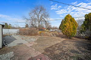 View of yard with fence and a patio