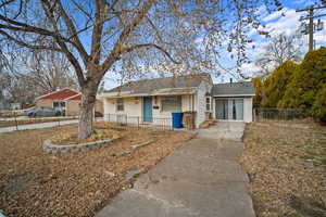 View of front of property with fence and roof with shingles