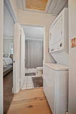 Laundry area featuring laundry area, light tile patterned floors, and stacked washer / drying machine