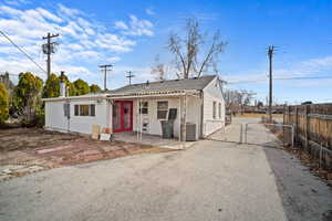 View of front of property featuring cooling unit, a gate, a patio area, and fence