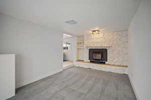 Unfurnished living room featuring carpet floors and baseboards