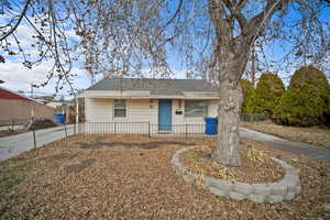 View of front facade with roof with shingles and a fenced front yard