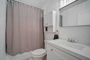 Bathroom featuring shower / tub combo, vanity, and toilet