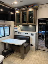 Kitchen with glass insert cabinets, light countertops, and backsplash