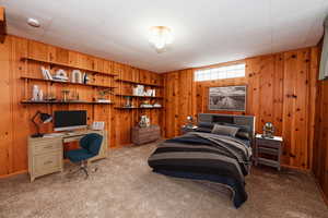 Carpeted bedroom with wooden walls