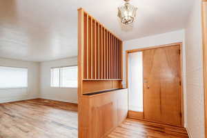 Interior space with a notable chandelier and light hardwood / wood-style flooring