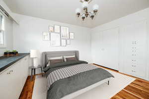 Bedroom featuring wood-type flooring and an inviting chandelier