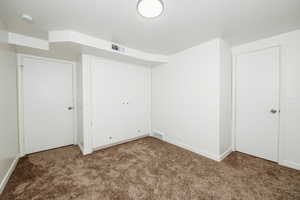 Unfurnished bedroom featuring carpet flooring, visible vents, and baseboards